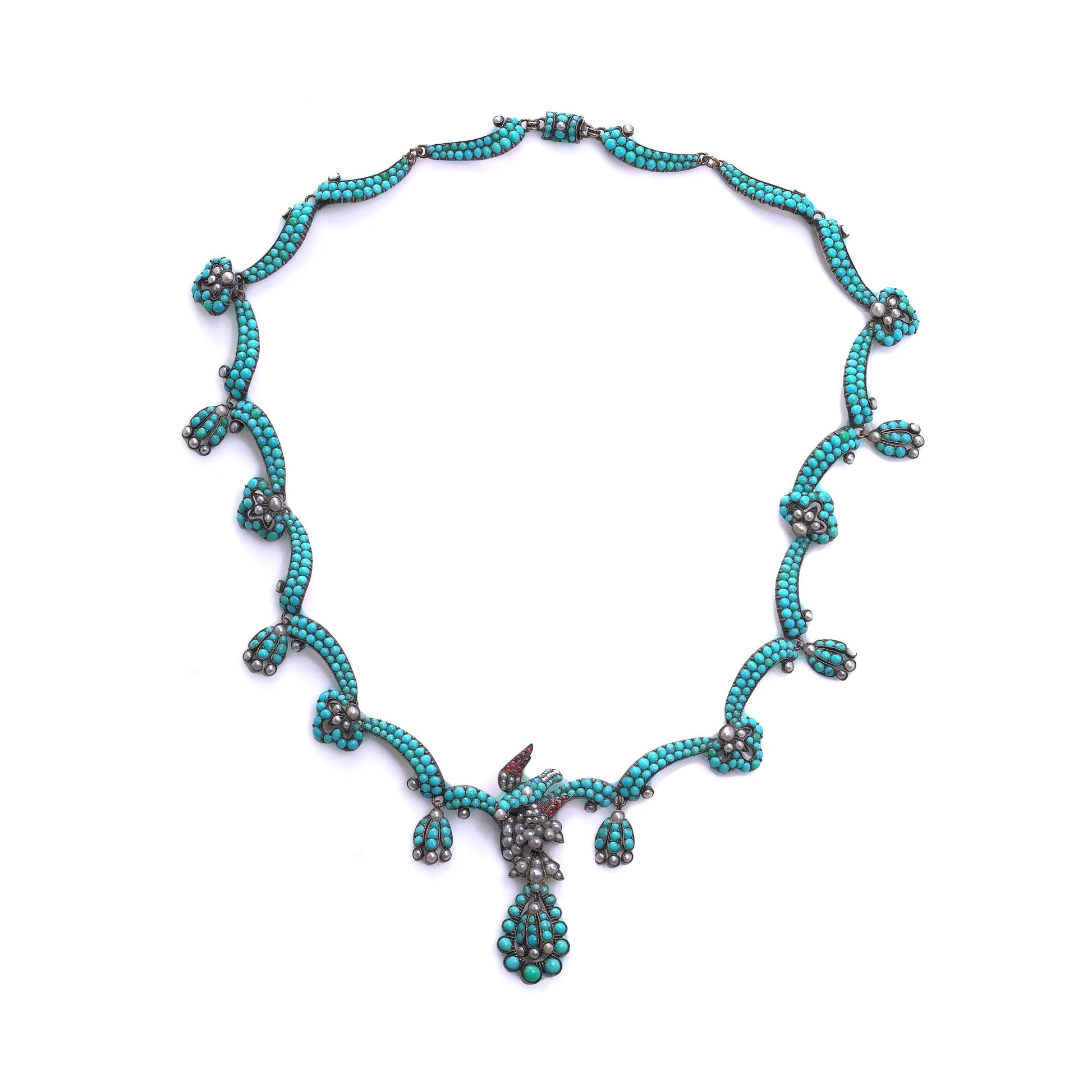 An antique turquoise bead and pearl fancy necklace with a bird motif, on a white background
