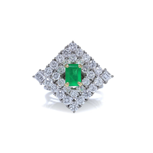 An emerald and diamond square shaped cluster ring in white gold, on a white background