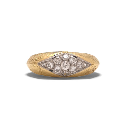 A yellow and white gold diamond ring with a textured shank, on a white background
