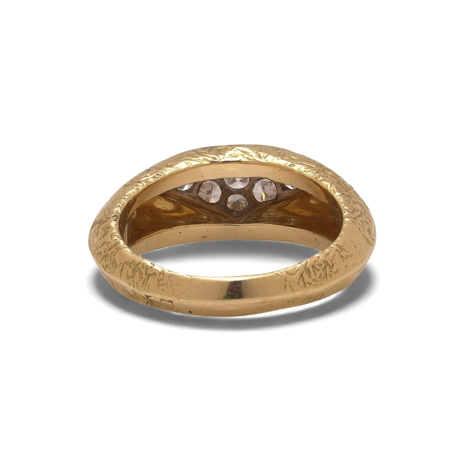 A yellow and white gold diamond ring with a textured shank, on a white background