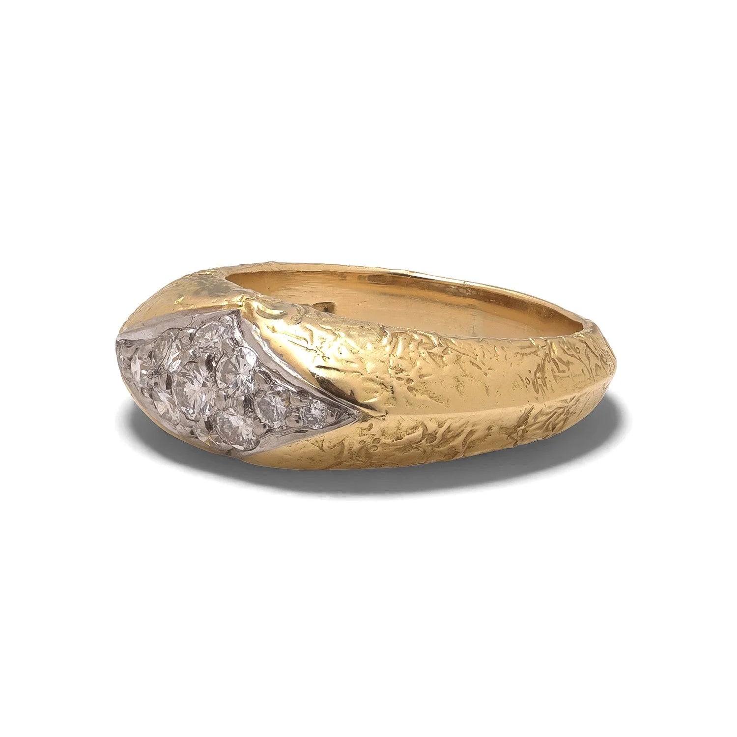 A yellow and white gold diamond ring with a textured shank, on a white background