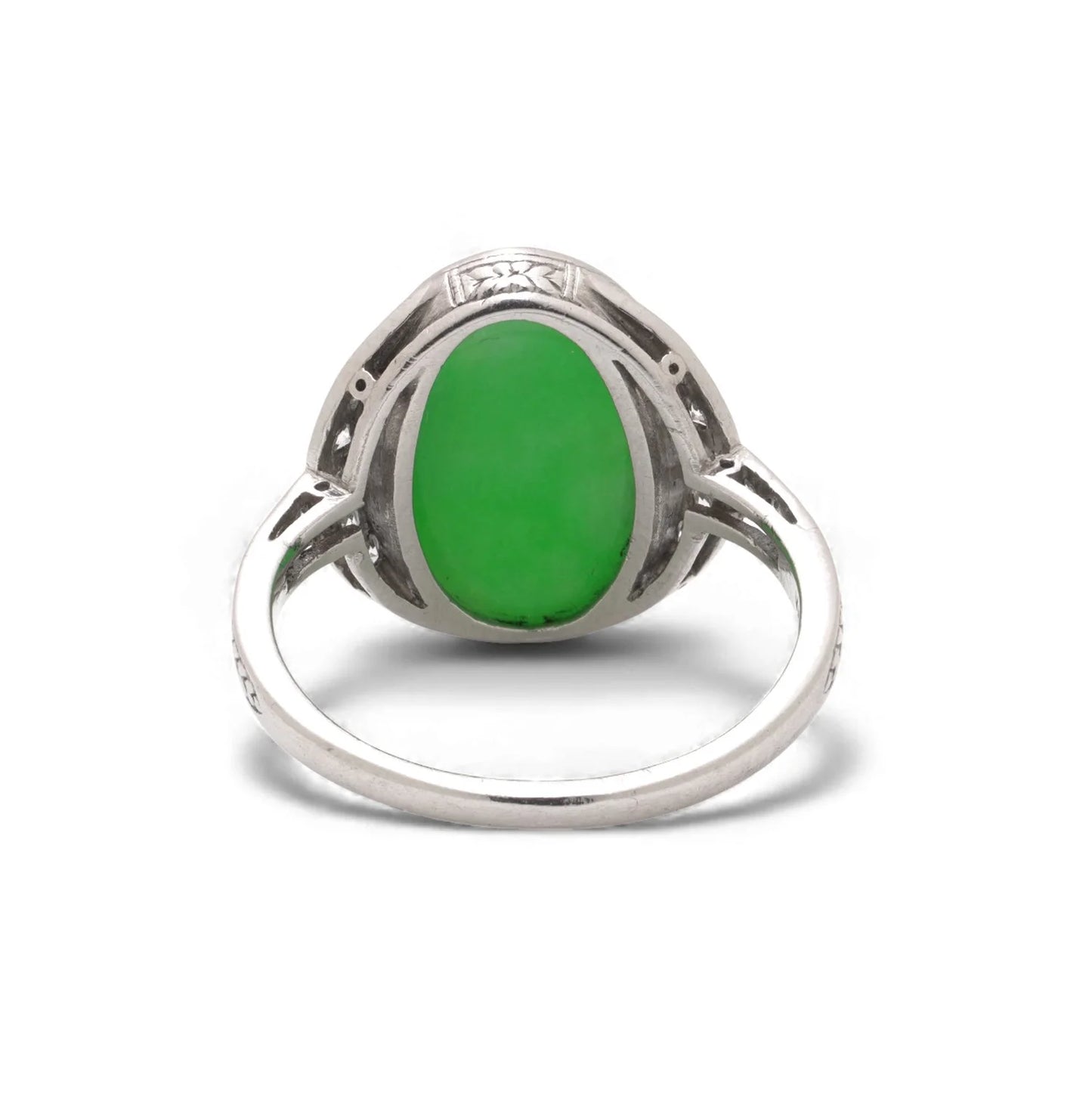 An Art Nouveau oval jade and diamond ring in platinum, against a white background