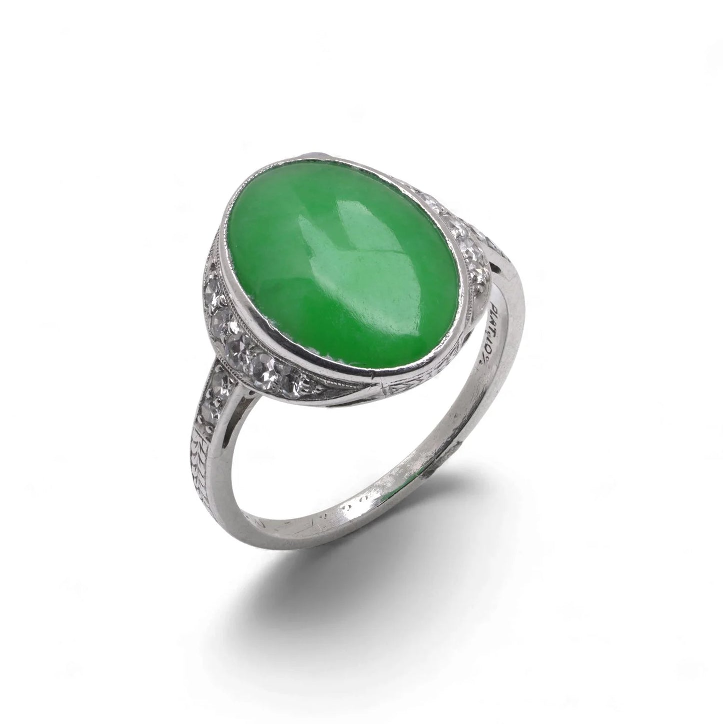 An Art Nouveau oval jade and diamond ring in platinum, against a white background