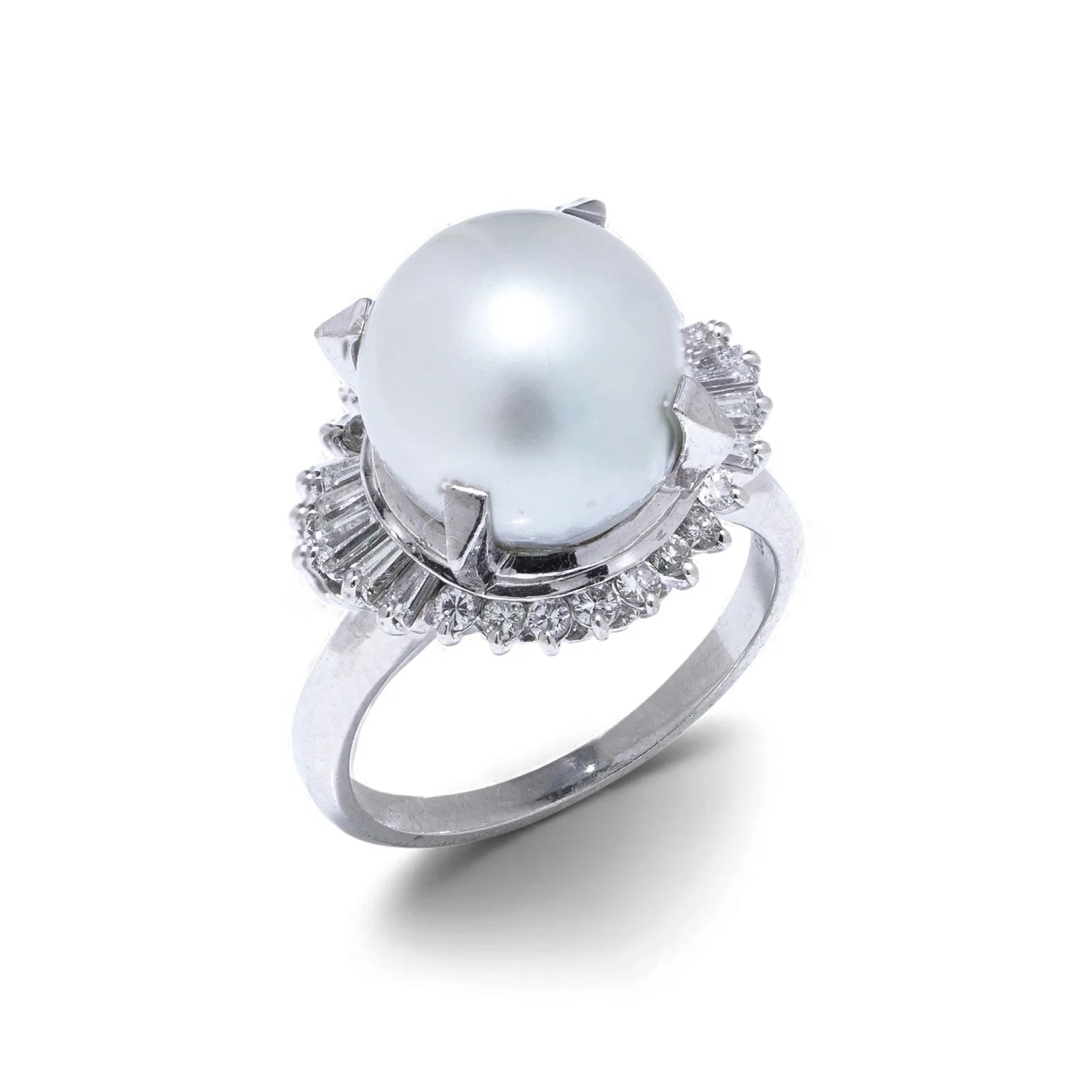 A platinum ring featuring a large white pearl surrounded by baguette and brilliant cut diamonds, on a white background