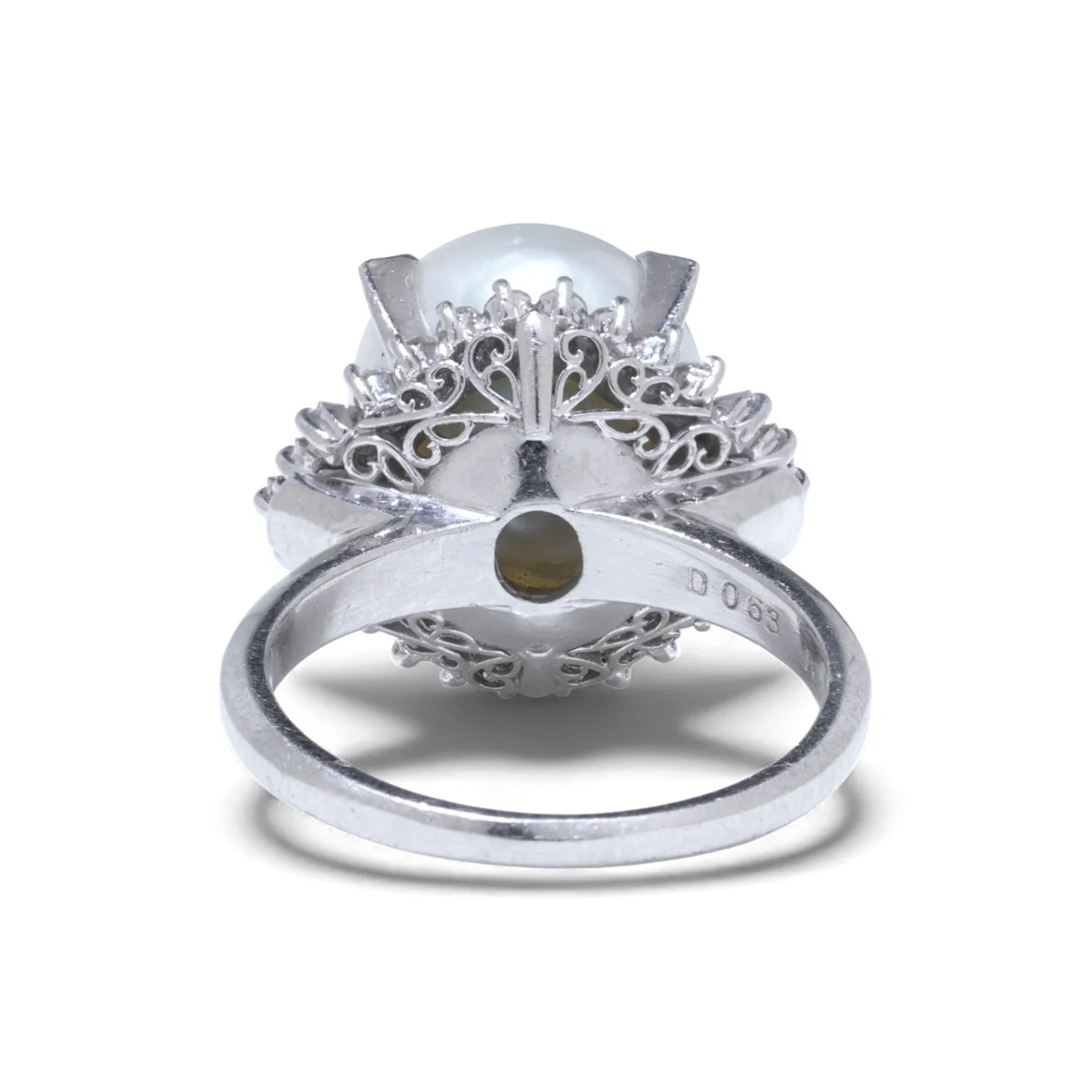 A platinum ring featuring a large white pearl surrounded by baguette and brilliant cut diamonds, on a white background