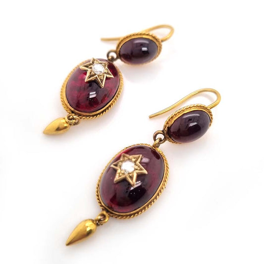 Victorian Antique Garnet and Diamond Drop Earrings, oval cabochon garnets suspend larger oval garnets with rose cut diamonds set to central stars in 18ct yellow gold with twisted gold wire surrounds and gold conical tear drops. Late 19th century Circa 1870