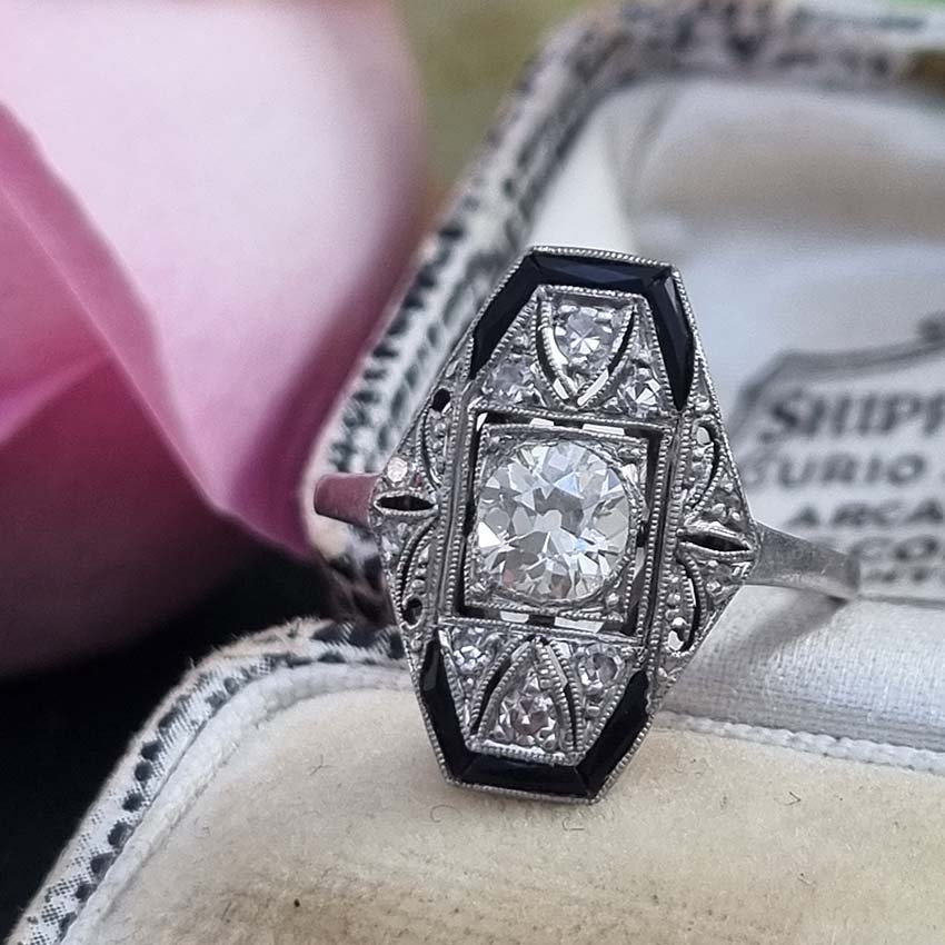 Art Deco Old Cut Diamond and Onyx Cluster Plaque Ring, 0.70ct old mine-cut diamond within tapered geometric surround of sparkling diamonds accented with rich black onyx in platinum. Circa 1920s