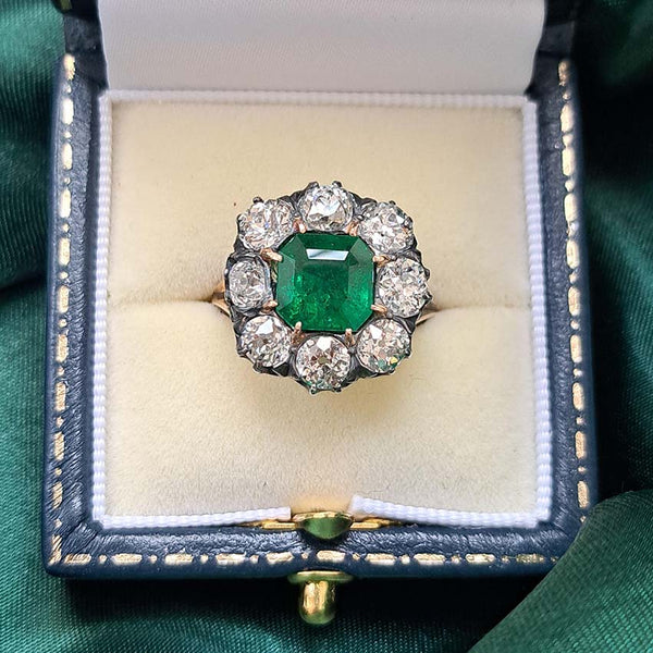 Emerald ring Georgian Regency Antique 2.85ct Colombian Emerald and 4.80ct Old Mine Cut Diamond Cluster Ring in silver upon gold with decorative carved split shank. Circa 1830