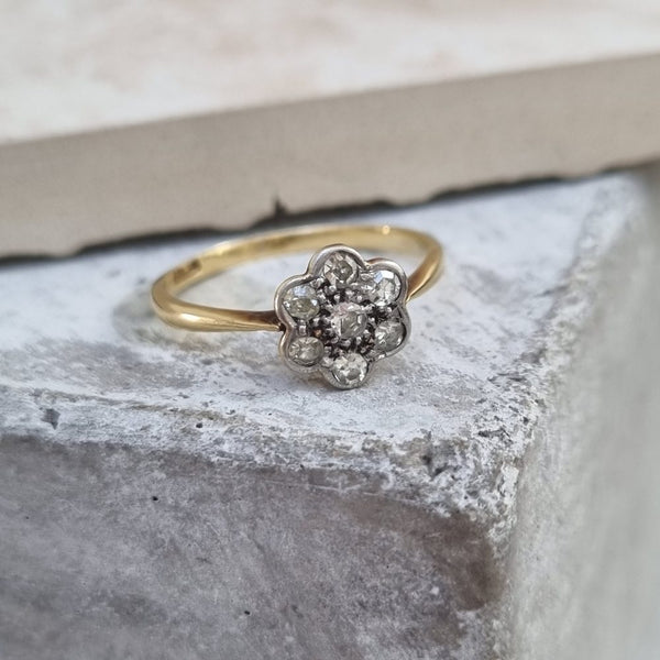 vintage diamond daisy cluster ring in 18ct gold, featuring seven round-cut diamonds in a floral design.