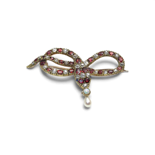 A yellow gold garnet, diamond and pearl set snake brooch