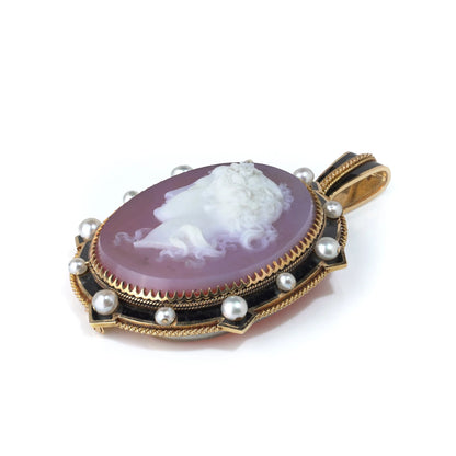 A cameo pendant in yellow gold with pearls and black enamel details