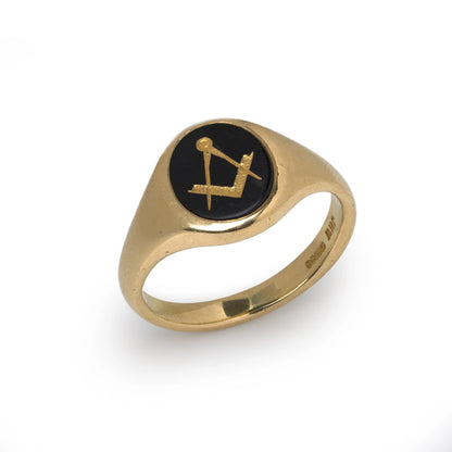 A yellow gold signet ring with an oval onyx masonic plaque