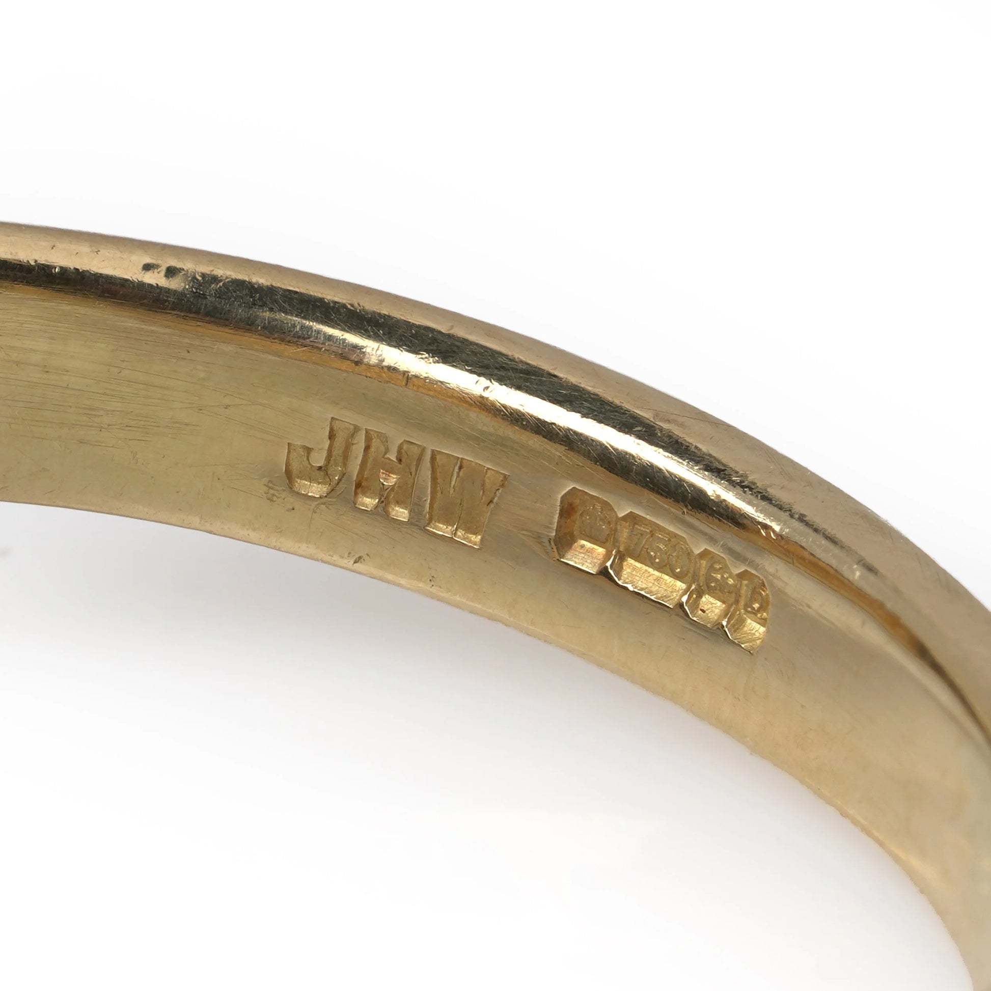 Close-up of an 18 carat gold hallmark inside a yellow gold ring shank