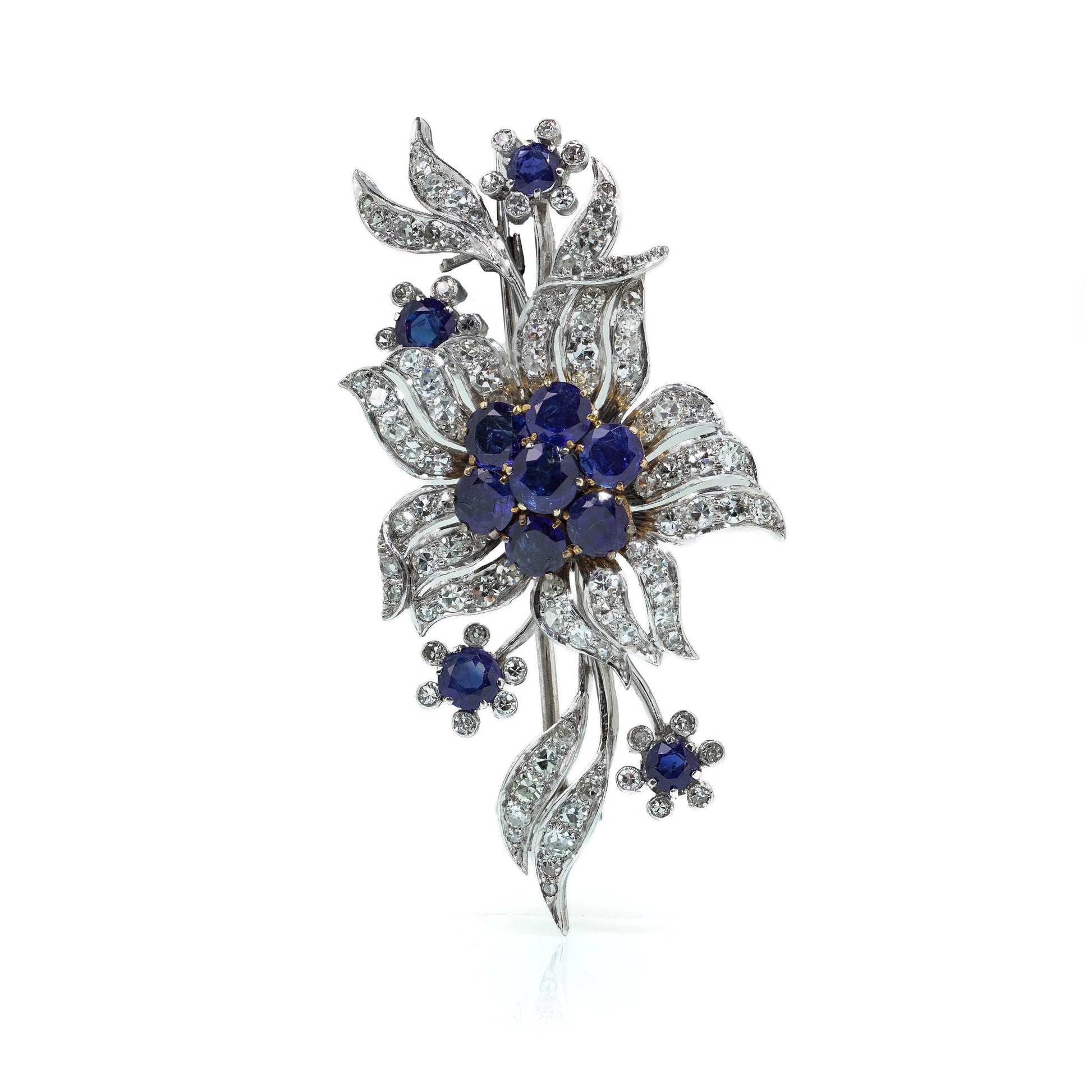 A flower spray brooch set with sapphires and diamonds, set in palladium