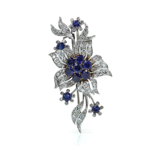 A flower spray brooch set with sapphires and diamonds, set in palladium