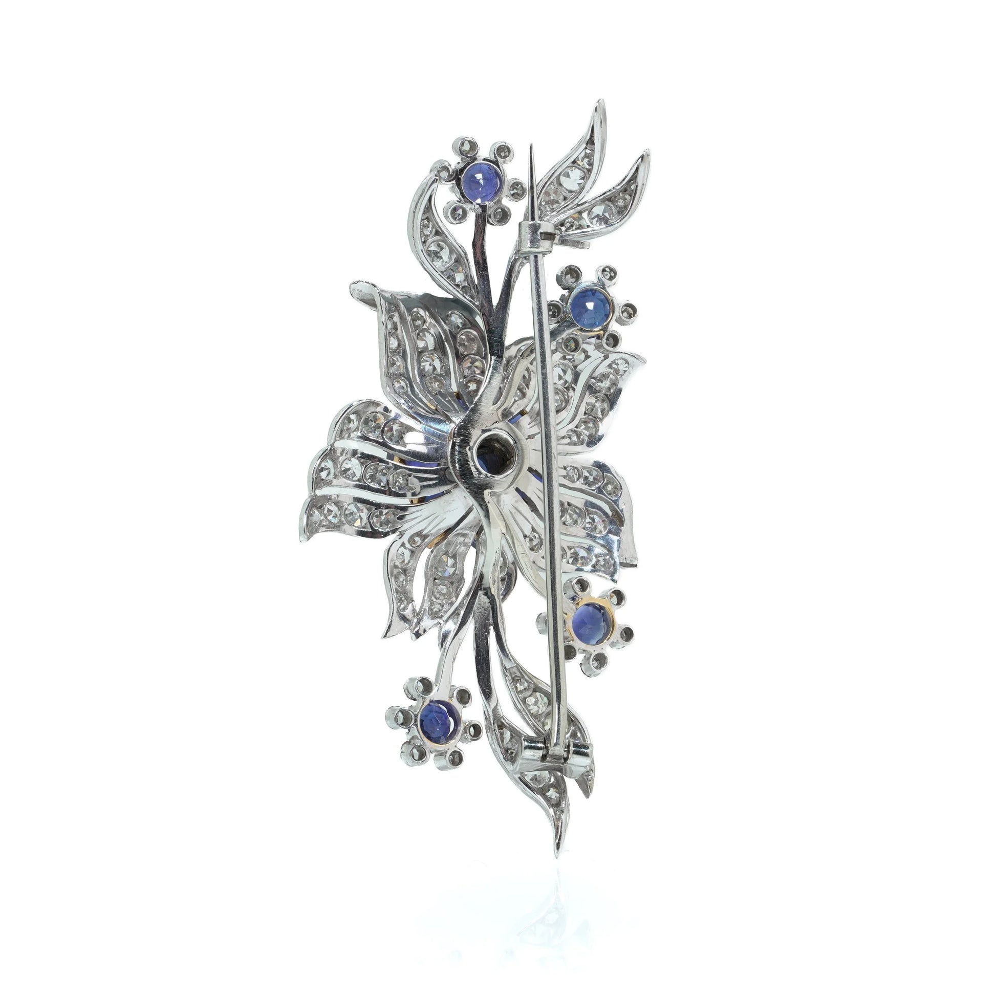 A flower spray brooch set with sapphires and diamonds, set in palladium