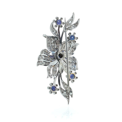 A flower spray brooch set with sapphires and diamonds, set in palladium