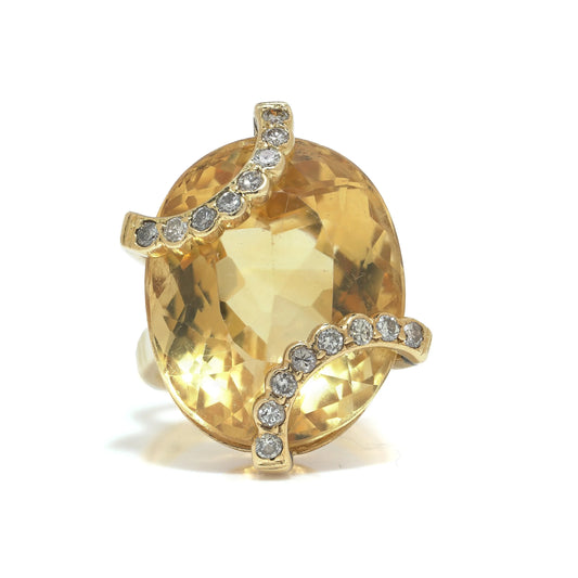 An oval citrine and diamond cocktail ring in yellow gold
