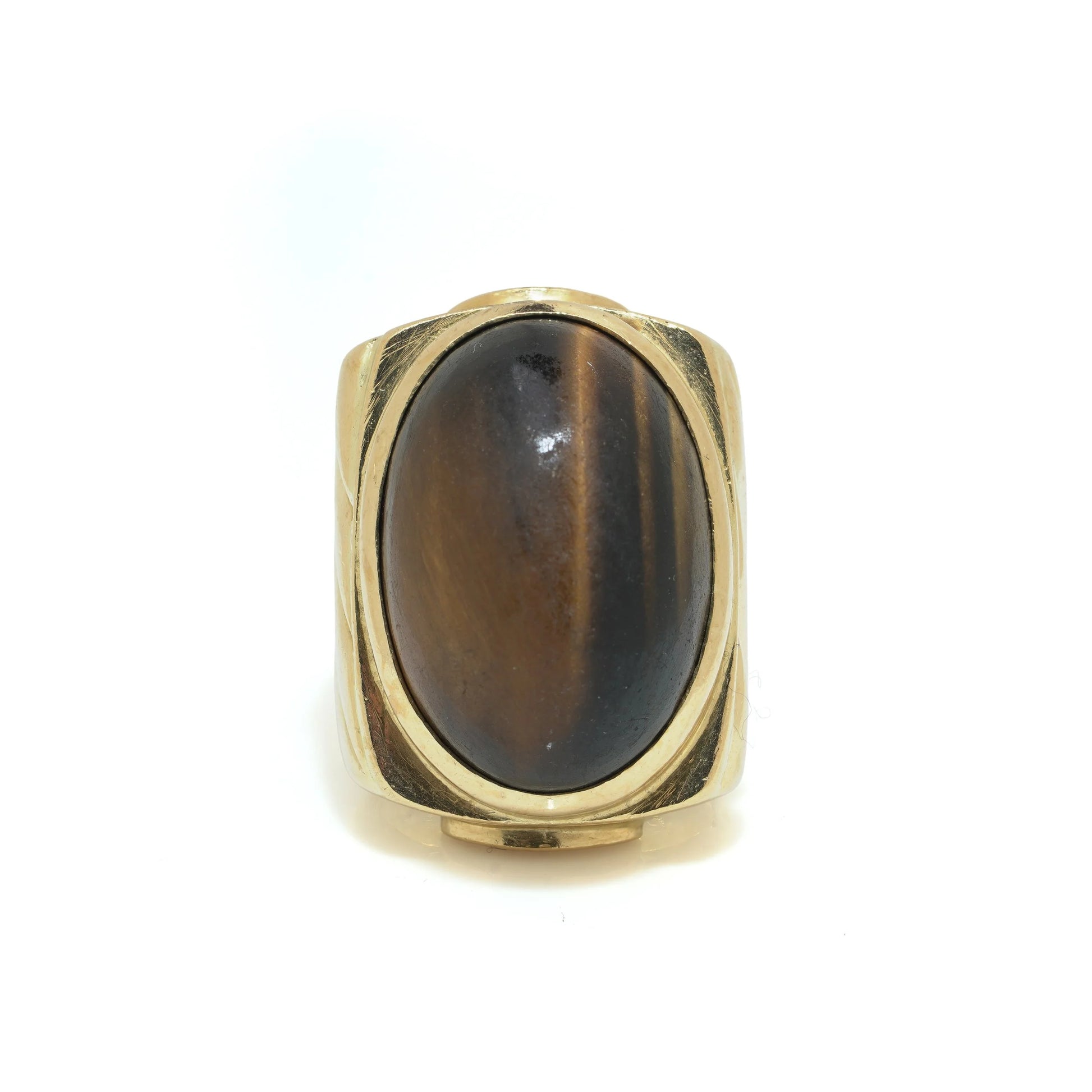 A yellow gold ring with an oval cabochon cut tiger's eye