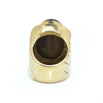 A yellow gold ring with an oval cabochon cut tiger's eye