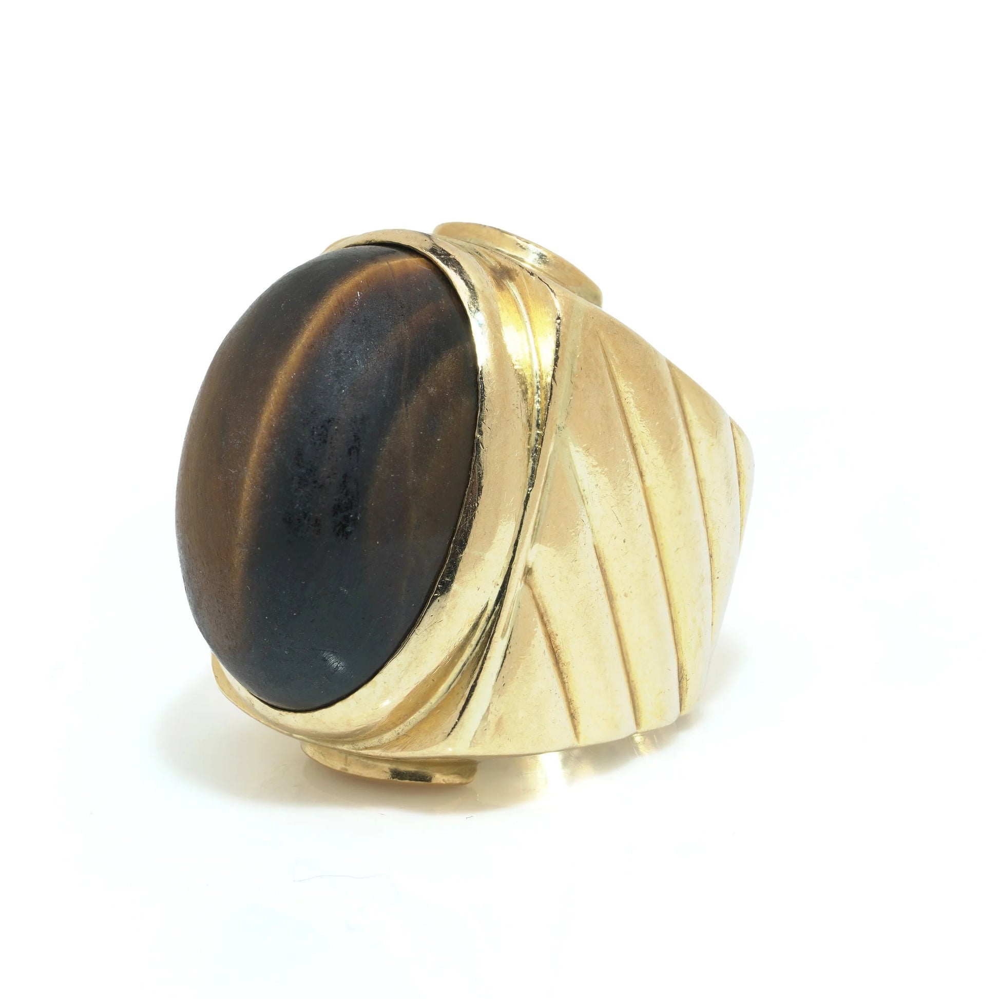 A yellow gold ring with an oval cabochon cut tiger's eye
