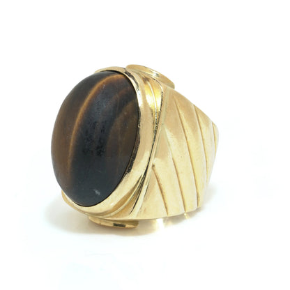 A yellow gold ring with an oval cabochon cut tiger's eye