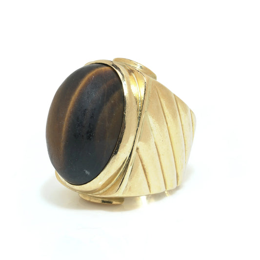 A yellow gold ring with an oval cabochon cut tiger's eye
