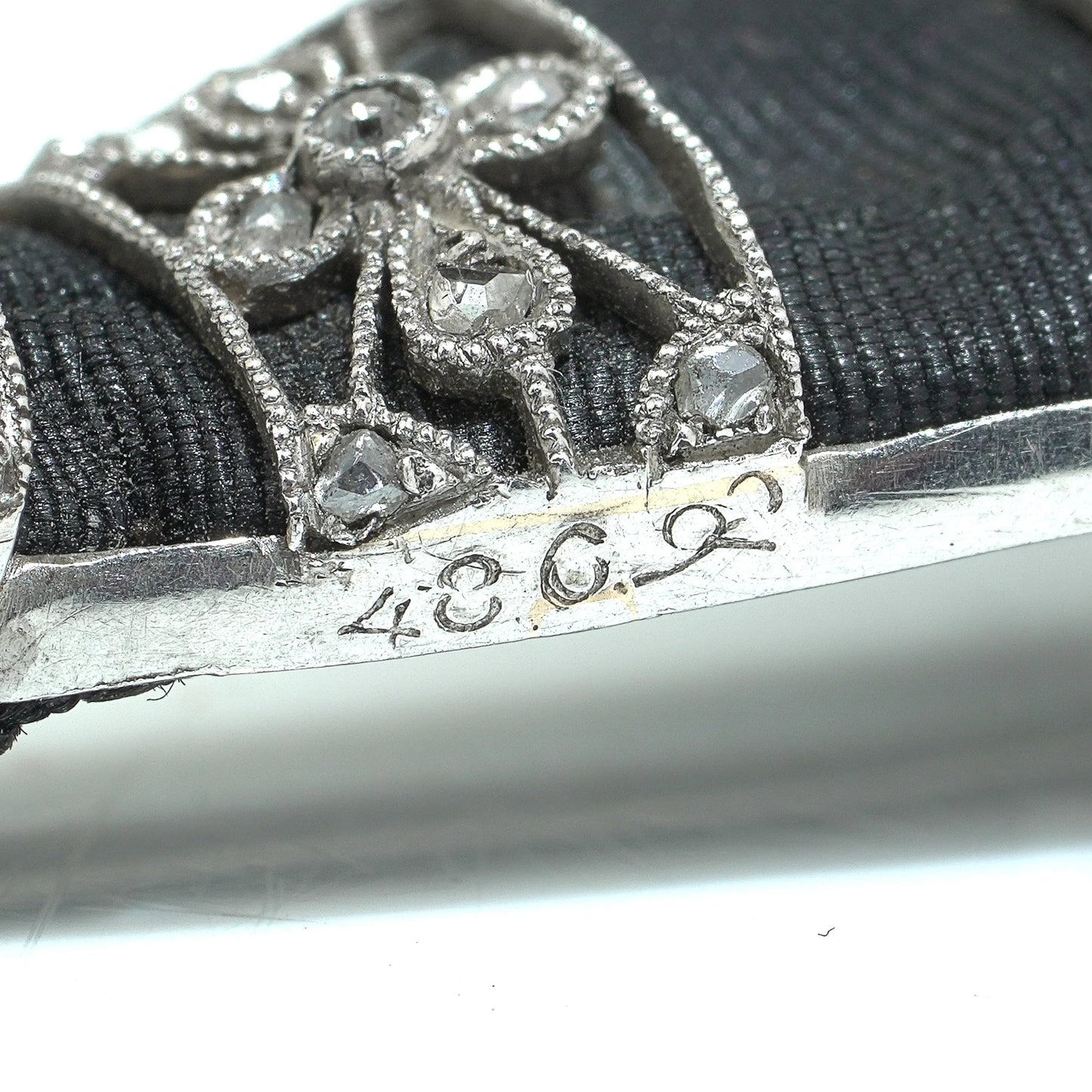 Close-up of a stamp on a diamond platinum brooch