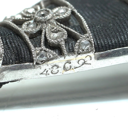 Close-up of a stamp on a diamond platinum brooch