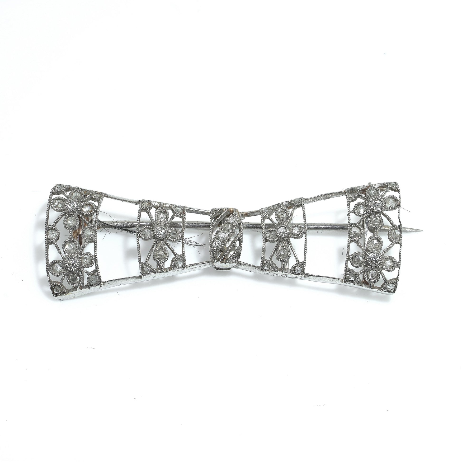 A floral design diamond and platinum bow brooch