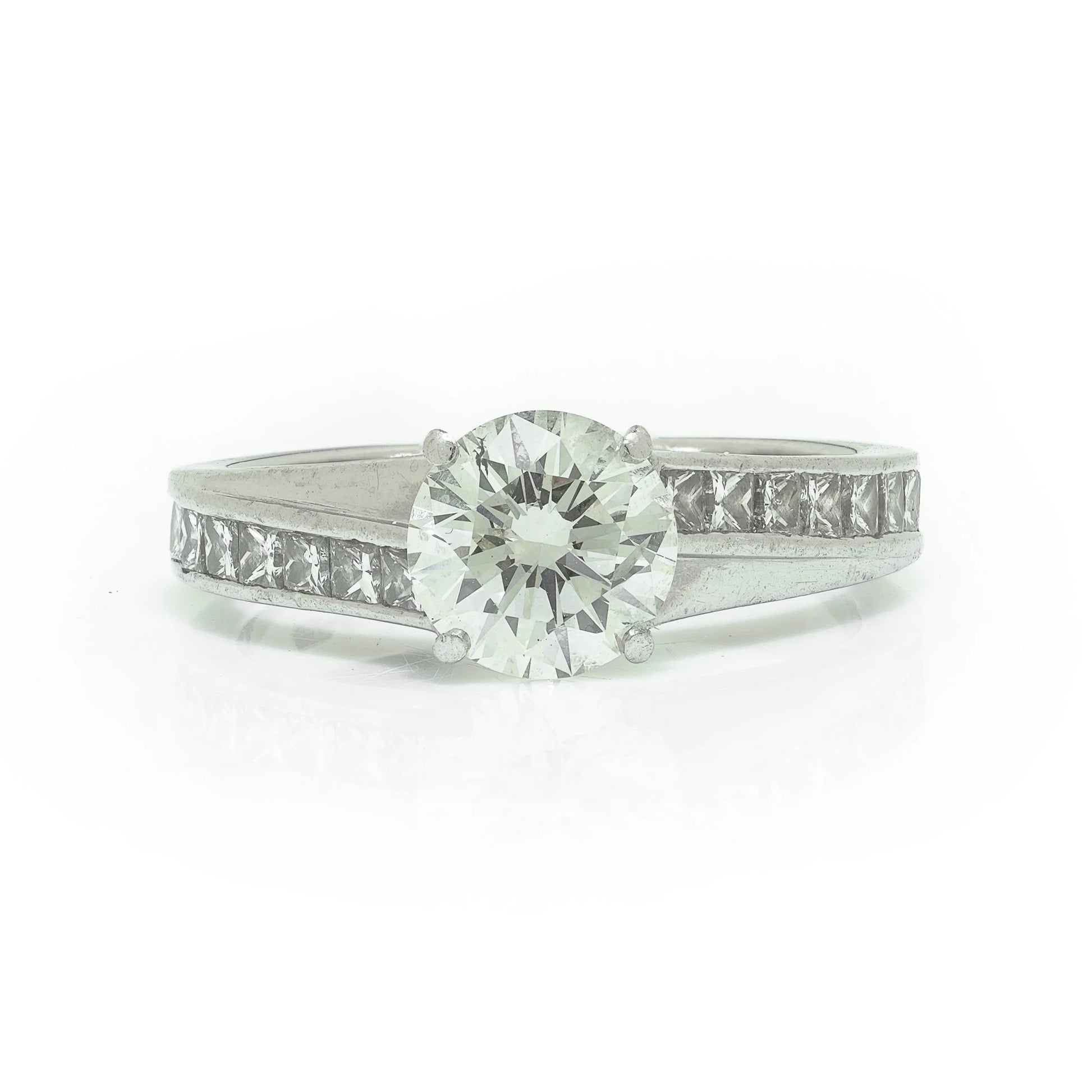 A brilliant cut diamond solitaire ring with square diamond set shoulders, in platinum