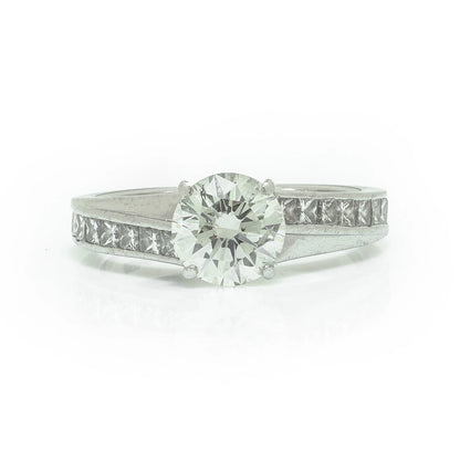 A brilliant cut diamond solitaire ring with square diamond set shoulders, in platinum