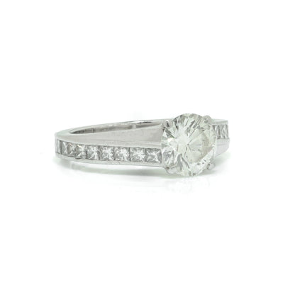 A brilliant cut diamond solitaire ring with square diamond set shoulders, in platinum