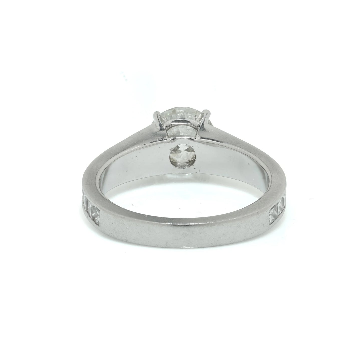 A brilliant cut diamond solitaire ring with square diamond set shoulders, in platinum
