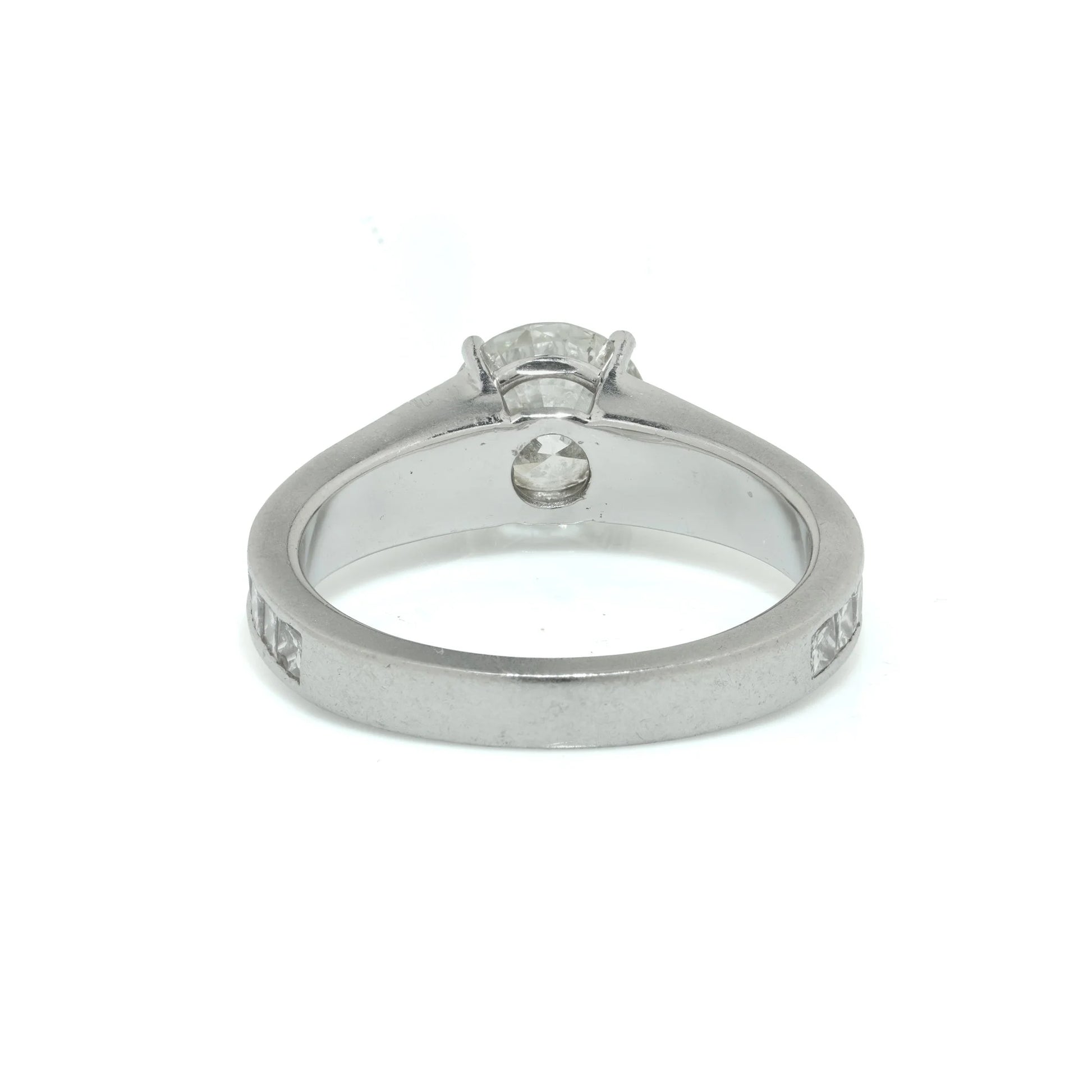 A brilliant cut diamond solitaire ring with square diamond set shoulders, in platinum
