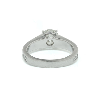 A brilliant cut diamond solitaire ring with square diamond set shoulders, in platinum