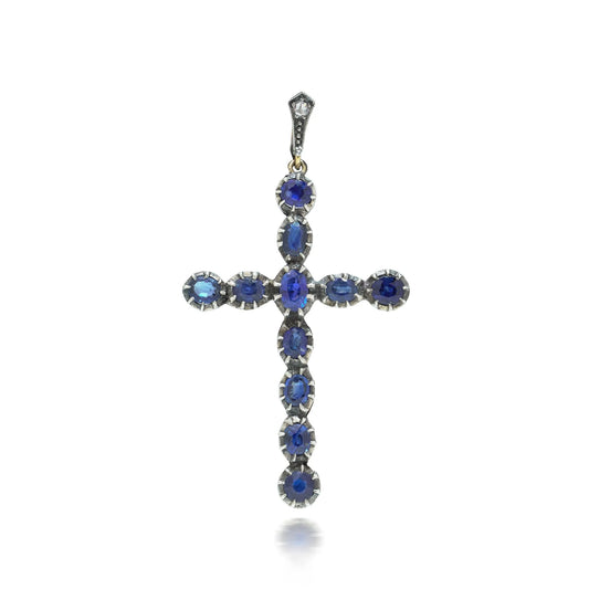 An oval blue sapphire cross pendant in silver and yellow gold
