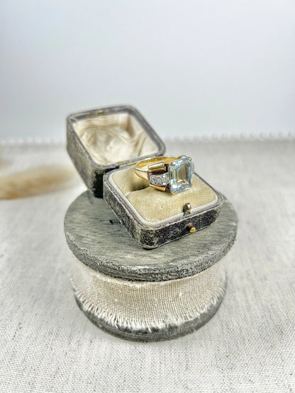 An aquamarine and diamond cocktail ring in gold, in an antique ring box