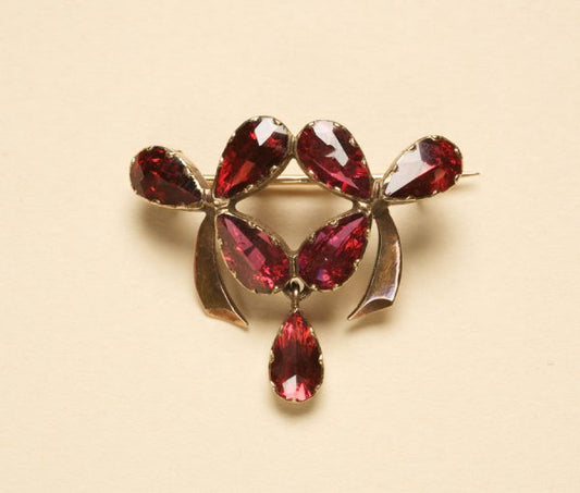 Art Nouveau Garnet and 18ct Yellow Gold Clover Brooch; set with foiled garnets in the shape of clovers, with garnet drop, in 18ct yellow gold. France, Circa 1900
