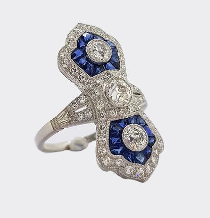 Art Deco Style Sapphire and Diamond Navette Panel Ring; navette-shaped ring set with brilliant-cut diamonds and calibre-cut sapphires. Mounted in platinum.