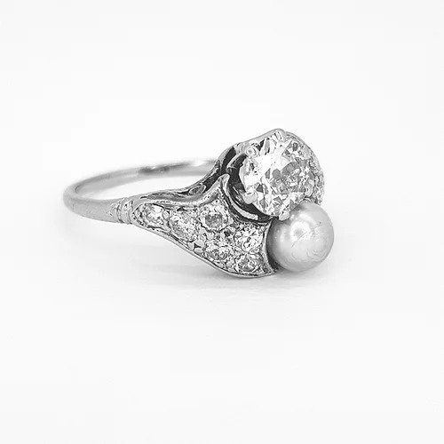 Belle Epoque Natural Pearl and Old Cut Diamond Ring; featuring an old cut diamond and grey natural pearl, diamond encrusted shoulders. Mounted in platinum with a pierced scrolled under-gallery