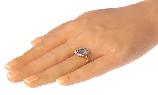 Vintage Aquamarine and Diamond Cluster Ring; central 4.17ct cushion-cut aquamarine surrounded by 0.52cts old-cut diamonds, in platinum and 18ct yellow gold, Circa 1920