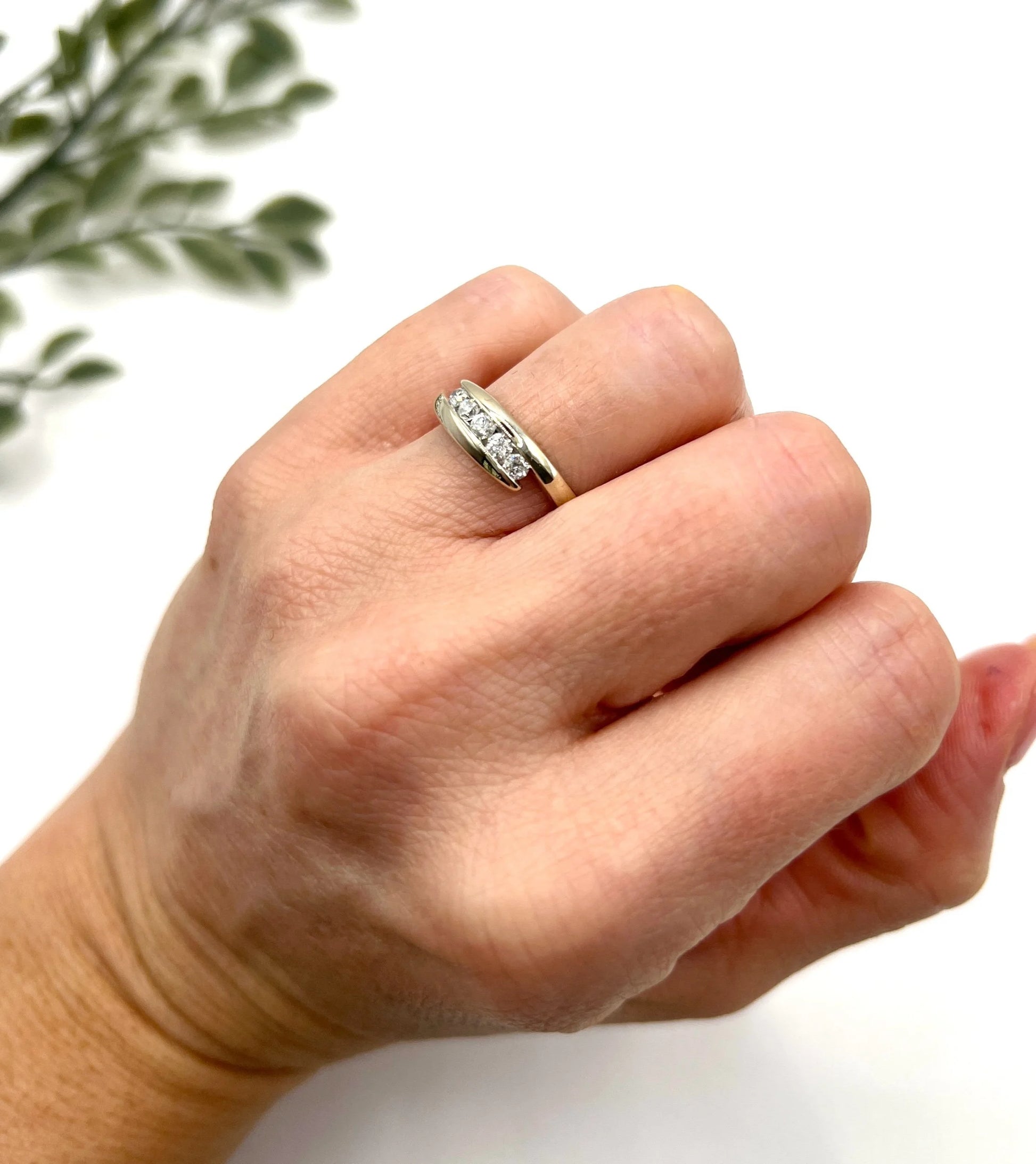 A five stone brilliant cut diamond ring in white gold, modelled on a hand