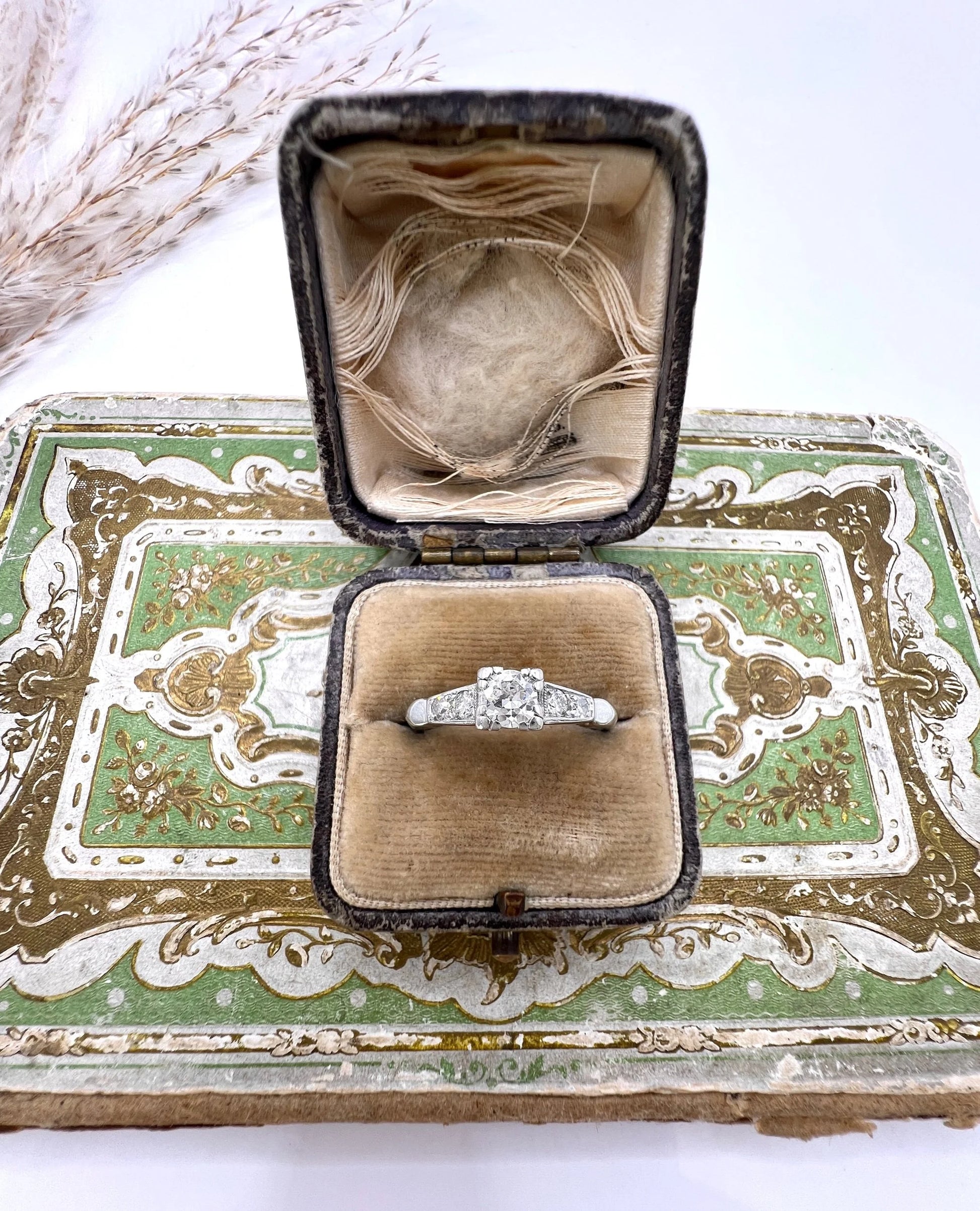 A solitaire diamond ring in platinum, with diamond set shoulders, in a ring box