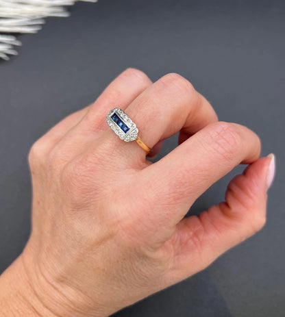 A sapphire and diamond elongated cluster ring in platinum and yellow gold, modelled on a hand
