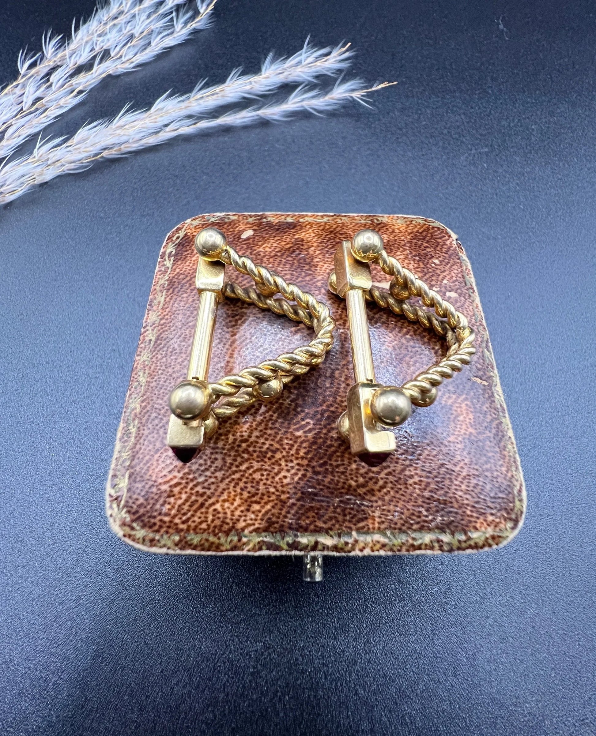 A pair of yellow gold ruby cufflinks, on an antique box