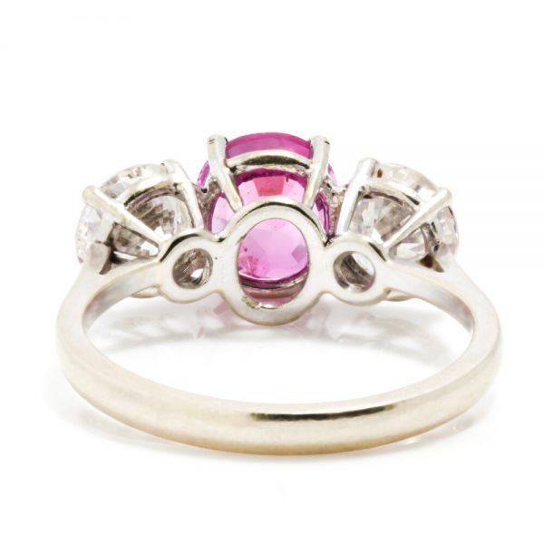 Natural Pink Sapphire and Diamond Three Stone Ring; central 1.50ct natural pink sapphire flanked by 2cts round brilliant-cut diamonds, all claw set in platinum