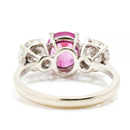 Natural Pink Sapphire and Diamond Three Stone Ring; central 1.50ct natural pink sapphire flanked by 2cts round brilliant-cut diamonds, all claw set in platinum