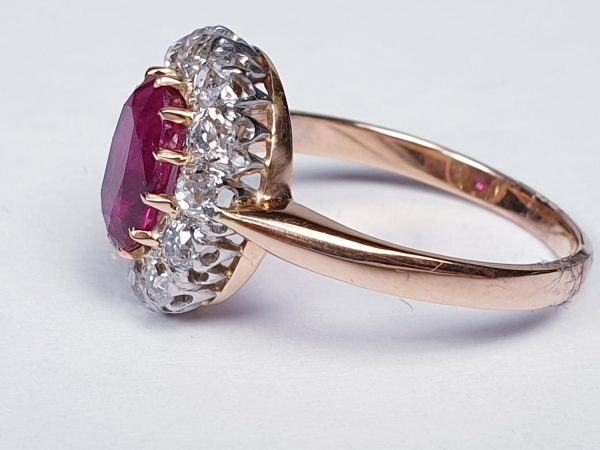 Antique Victorian Ruby and Diamond Oval Cluster Ring; featuring a 1.15 carat oval faceted ruby encompassed by 1.20cts sparkling diamonds, on a rose gold shank. English, Circa 1890