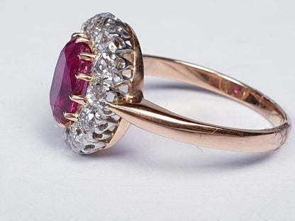 Antique Victorian Ruby and Diamond Oval Cluster Ring; featuring a 1.15 carat oval faceted ruby encompassed by 1.20cts sparkling diamonds, on a rose gold shank. English, Circa 1890
